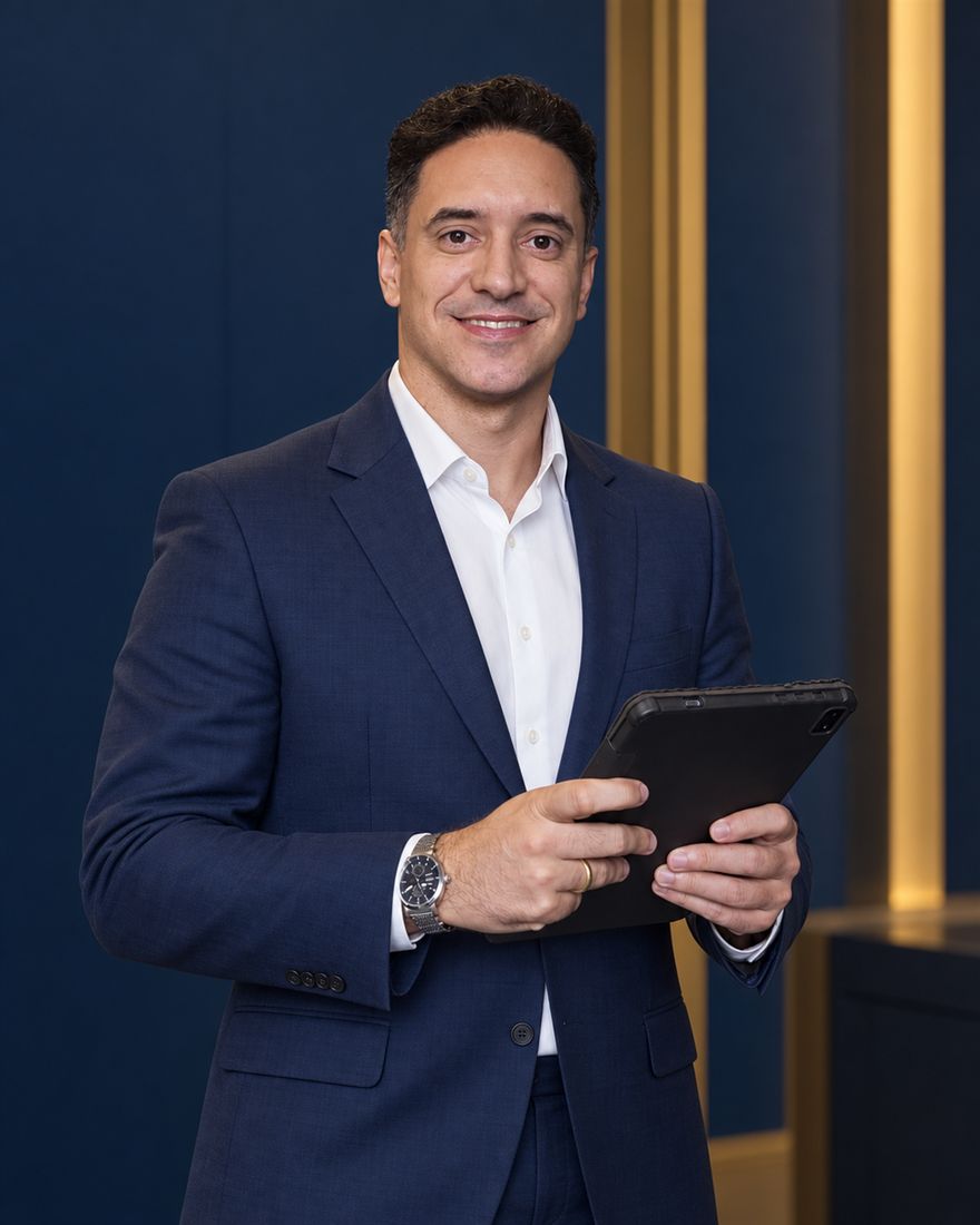 Guilherme Damasceno, advogado de empresas, em seu escritório, segurando um tablet